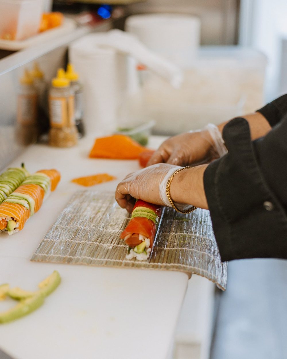 De chef rolt een sushi met de hand op